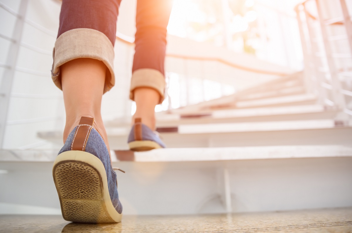 Close-up of feet in sneakers climbing stairs.