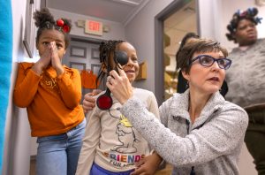 A woman gives a young girl an eye exam